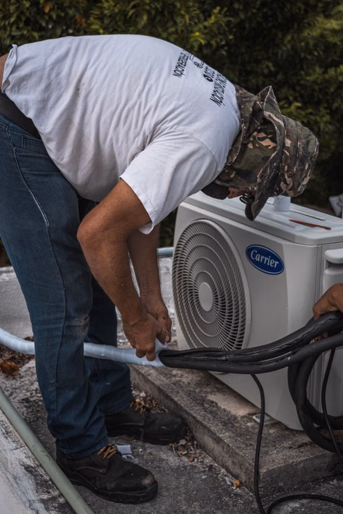 Technician performing AC maintenance and cleaning