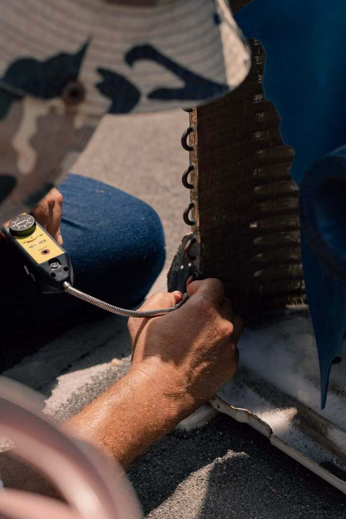Technician repairing an air conditioner with tools