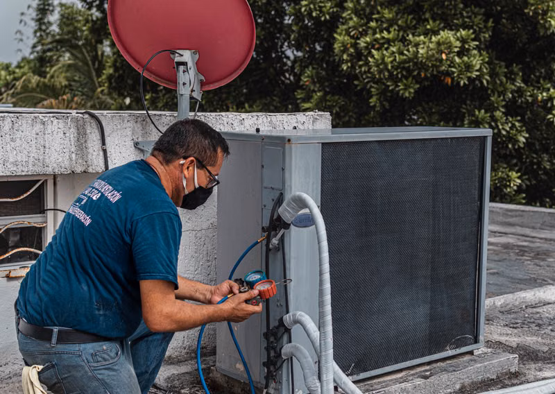 Technician checking refrigerant gauge for genuine parts